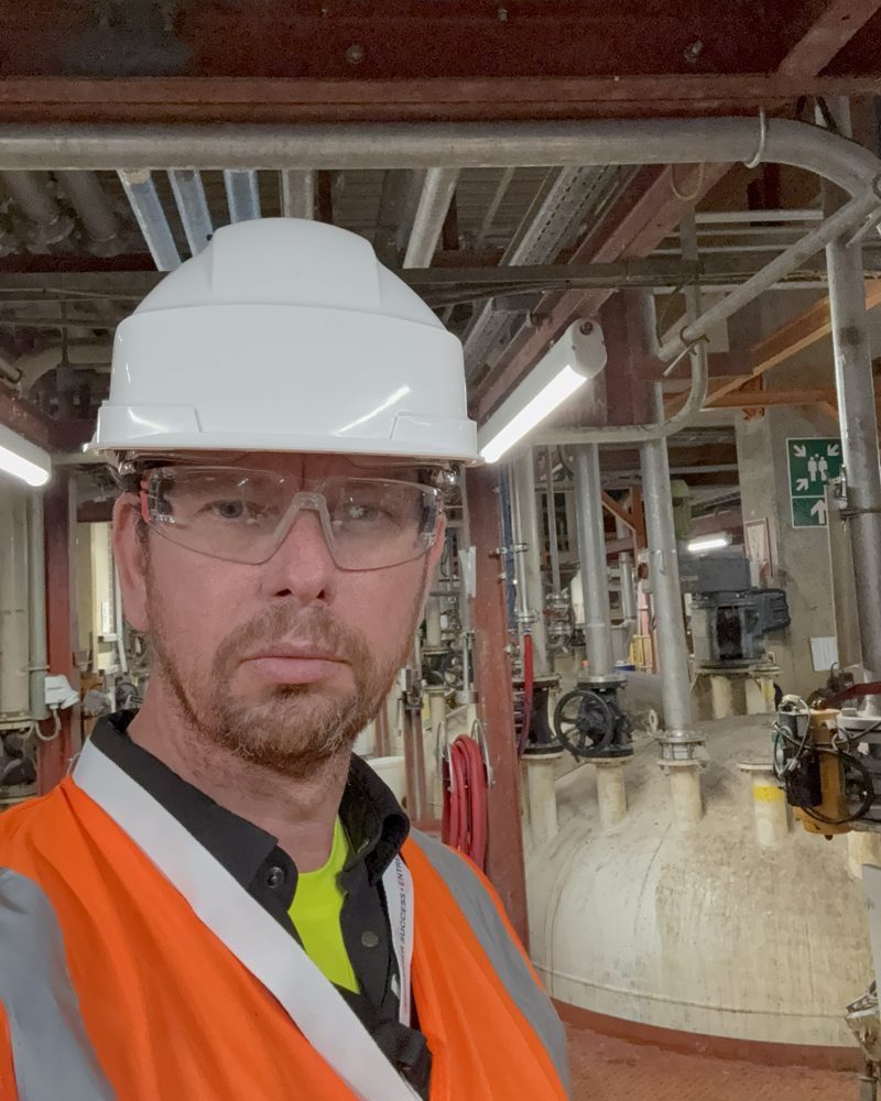 Peter van Roosmalen met helm en veiligheidsbril in een procesinstallatie.